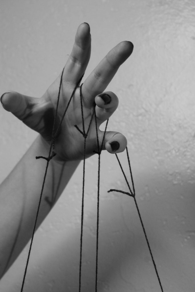 hand holding puppet strings