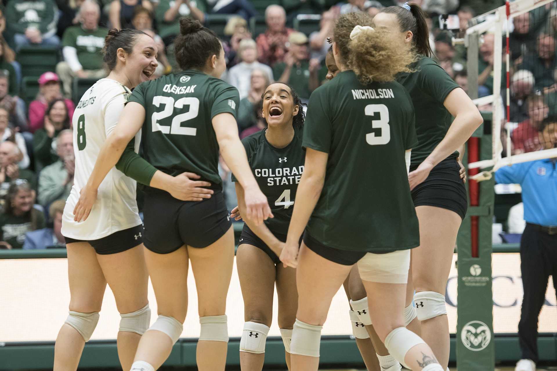 Freshman Brooke Hudson celebrates a point in the huddle with her volleyball teammates in the second match.