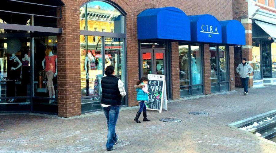 A family walks past Cira Boutique in Old Town.