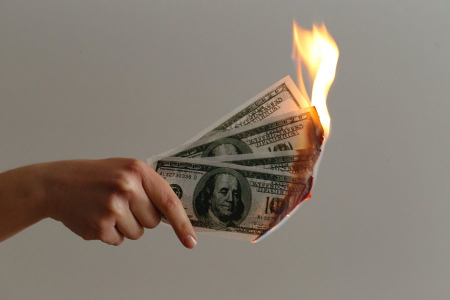 three one hundred dollar bills on fire
