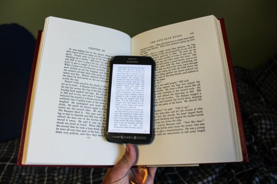 phone with text opened on it lying in the middle of an open book