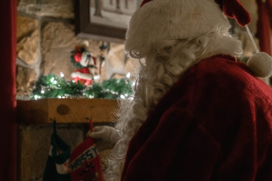 Santa from behind in front of a fireplace