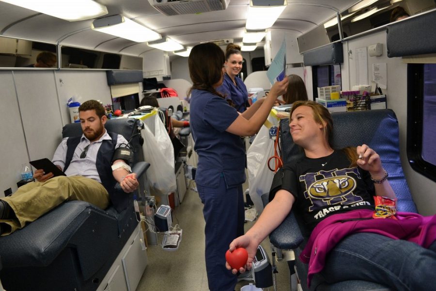 Jay Kailey, a second year nursing student, and Nick Millisor, a third year business and finance major, donate blood at the onsite Bonfills Blood Donation bus just outside the Warner College building.