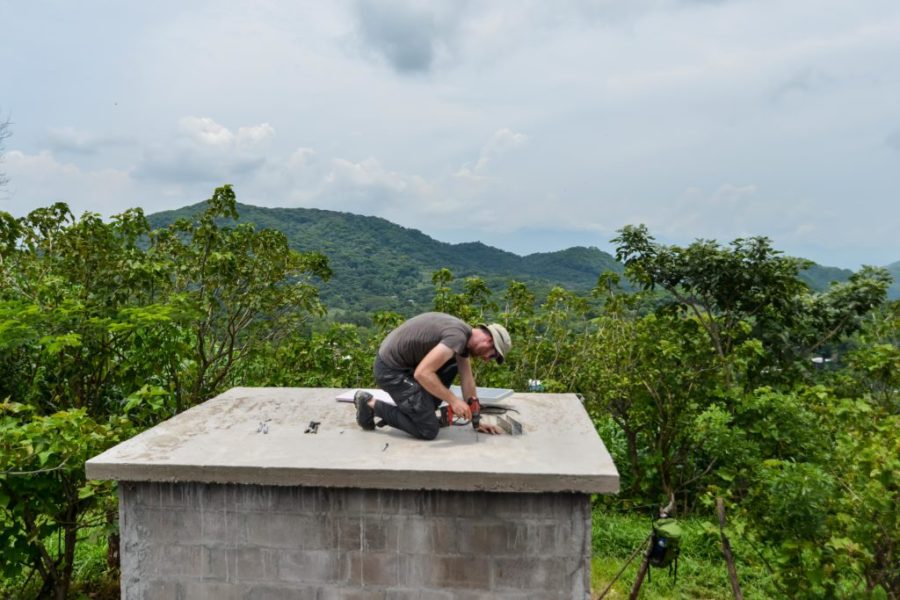 La Criba, El Salvador- La Criba Project Lead, Peter Field drills a whole for the solar panel and antennae on top of the tank house. Photo credit: Priscilla Vazquez