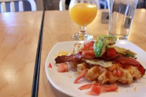 The Blue Sky Breakfast waffle piled high with eggs, bacon, tomatoes and avocado.