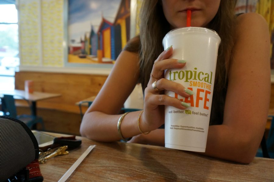 white person holding smoothie from tropical smoothie cafe