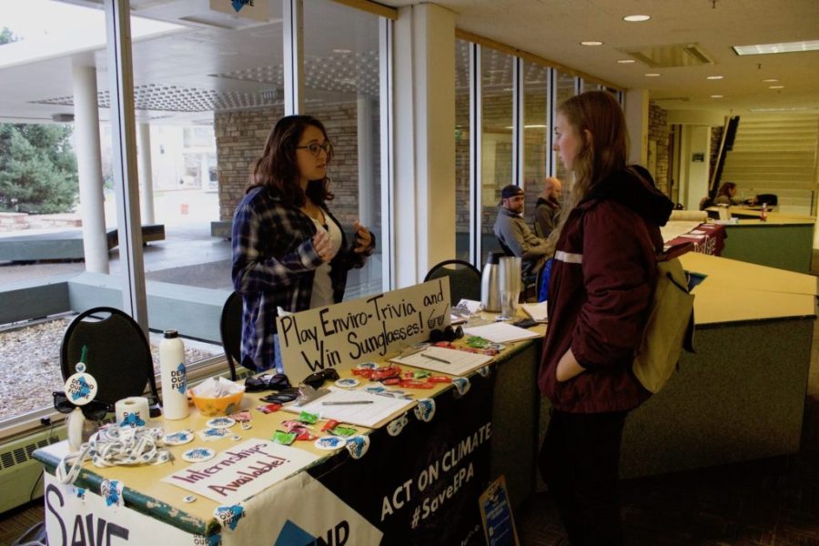 Student talks to a Defend Our Future volunteer at the organizations table set in the Lory Student Center at CSU. Photo credit: Abby Flitton