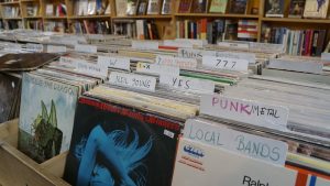 Stacks of vinyl records arranged by genre.