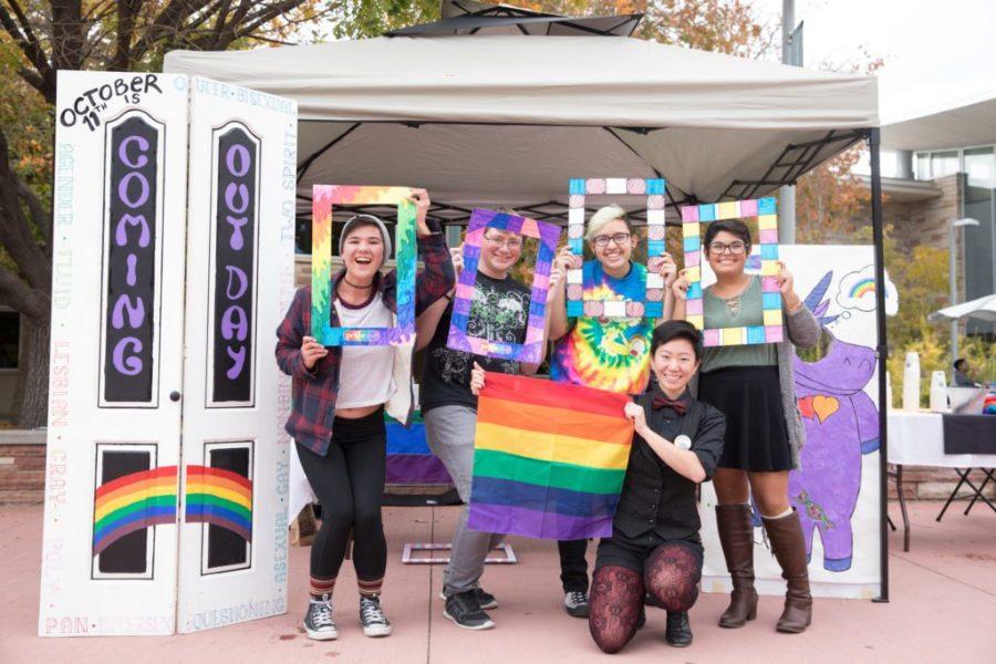 white students posing for group photo with rainbow items