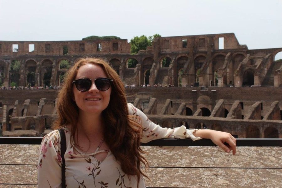 woman standing in front of colosseum