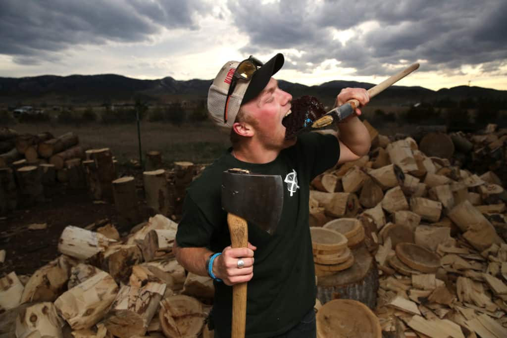 a man eats cake off an axe head
