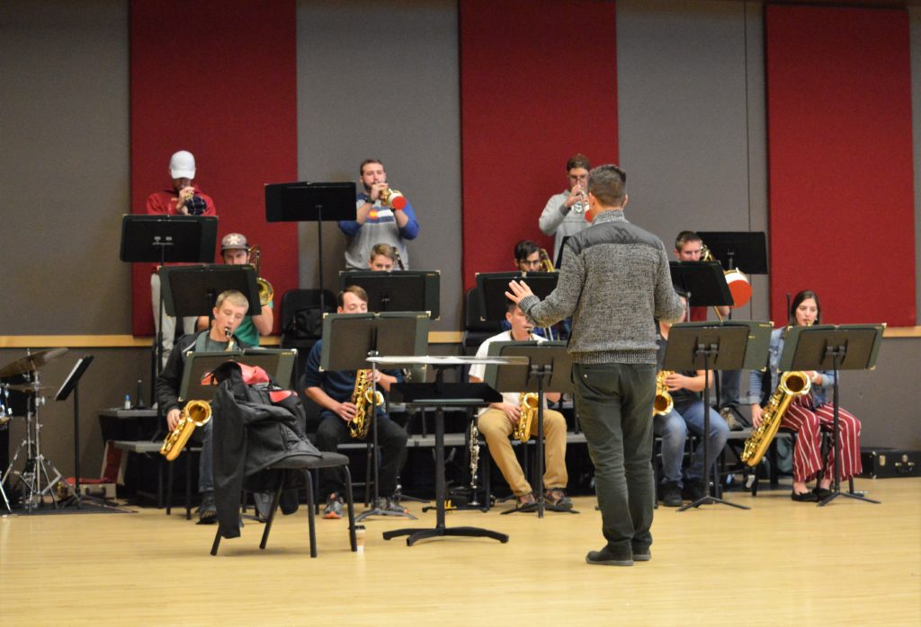 man conducts student performers