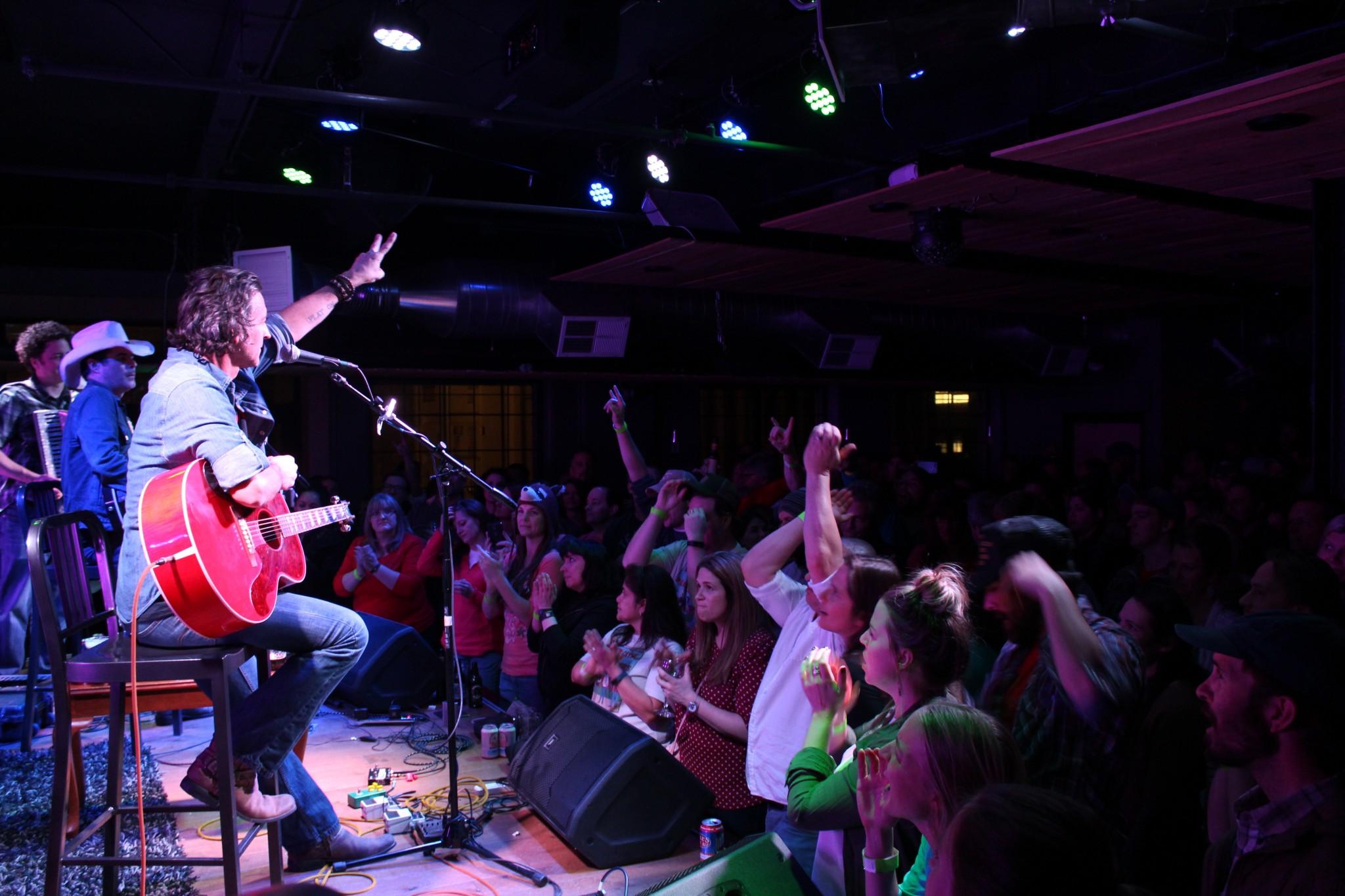 Roger Clyne does the peace sign to the crowd at the Downtown Artery, accompanied by Jim Dalton (center-stage) and Jeremy Lawton (far left) 