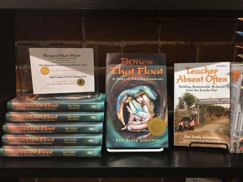 Books "Bones That Float" and the youth edition "Teacher Absent Often" sit on a display shelf
