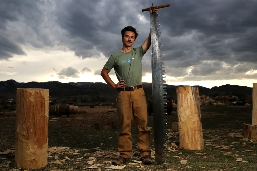 a man stands with a tall saw