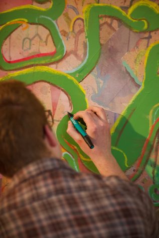Jackson Aldern works on a painting in his studio Oct. 26. Aldern, a Colorado State University alumnus and founder of Half Snake Art Collective, said his exploration with this piece is “super materialistic and almost entirely based on color.”