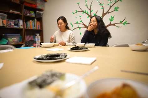 First Korean Church of Fort Collins young adult bible study members Hyemi Woo (left) and Ebony Lee (right) eat kimchi-jigae, made by a church member, for dinner before starting their weekly bible study, March 23, 2022. (Anna von Pechmann | College Avenue Magazine)