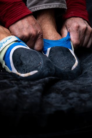 Jason Tarry puts on climbing shoes.