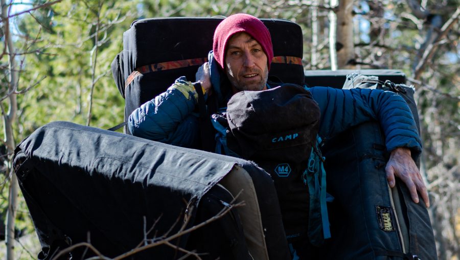 Ben Scott carries four crash pads and a backpack.