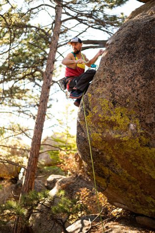 Aaron Ramas scrubs the holds on an unclimbed project.