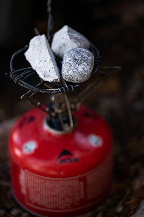 Ben Scott heats up rocks on a portable stove.