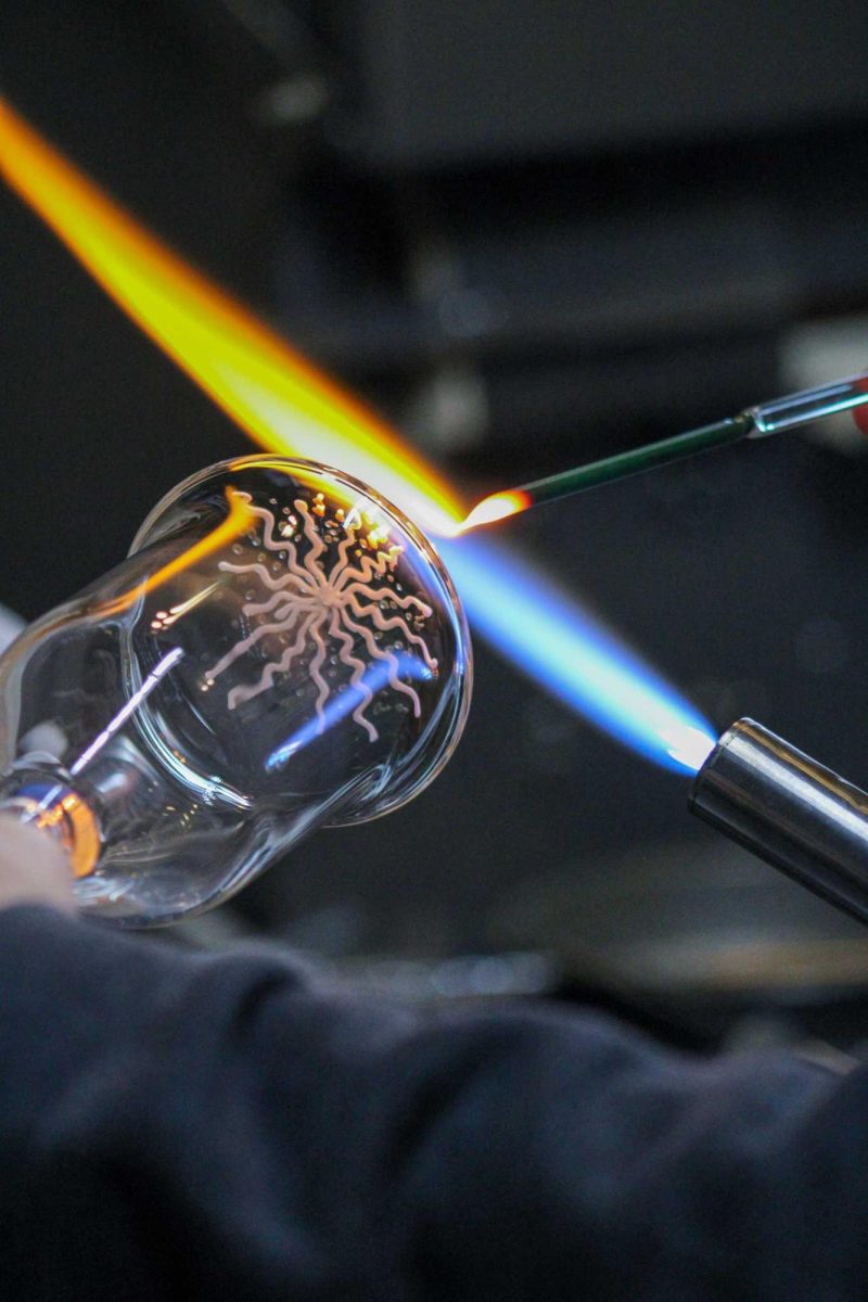 Bryan Ratcliffe, a local glass blower, creates the beginning of a mountain design in the bottom of a glass Nov. 2, 2021.