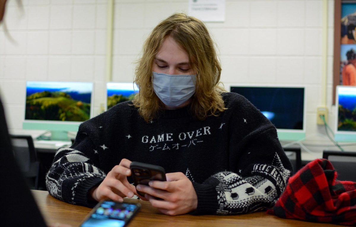 Brayden and Erica sitting together in a classroom in the Clark C building on the Colorado State University campus, scrolling on social media Feb. 19. 